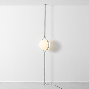 Oris floor to ceiling lamp in Silver switched on against a white wall, real product photo, full length
