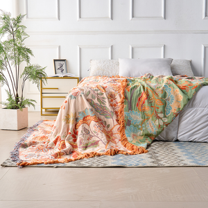 Rustic floral boho cotton throw blanket across a bedroom bed