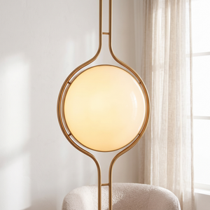 Oris floor to ceiling lamp in Gold lit beside a window with sheer linen curtains