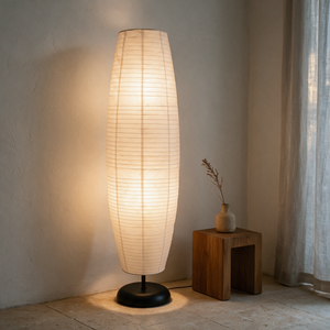 Anara floor lamp lit in a Japandi corner beside an oak stool and ceramic vase