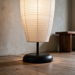 Close up of the Anara floor lamp matte black pebble dome base and slim stem on an oak floor