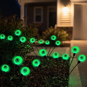 Green glowing eye orbs staked beside a front walkway at night