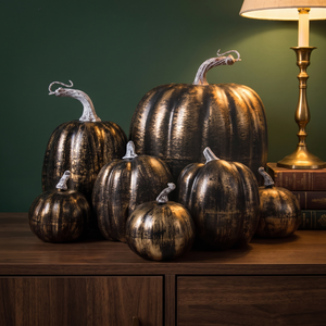 Bronze and black decorative pumpkins on a walnut sideboard