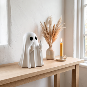 White ghost statue on a console table with dried grasses