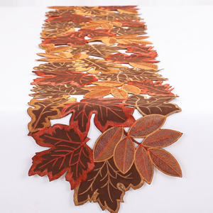 Embroidered autumn leaf table runner on a white background