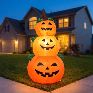 Inflatable pumpkin stack glowing on a lawn at blue hour