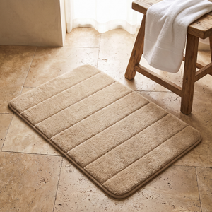 Khaki bath mat on a travertine bathroom floor