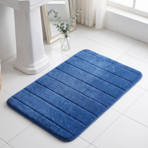 Light blue bath mat in front of a pedestal sink