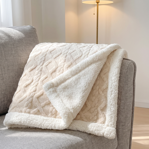 Creamy white sherpa fleece blanket over a grey armchair