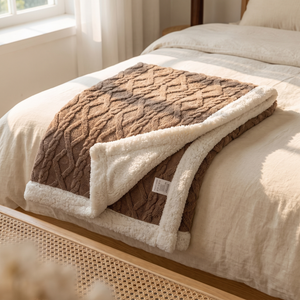 Espresso sherpa fleece blanket folded across a bed