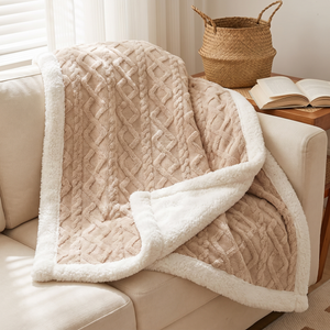 Latte sherpa fleece blanket over the back of a cream sofa