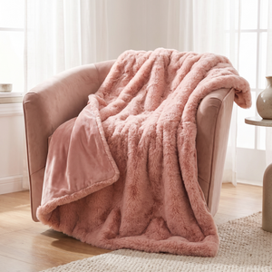 Rose blush faux fur throw over a velvet armchair