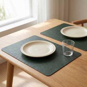 Green faux leather placemats on a pale wood table