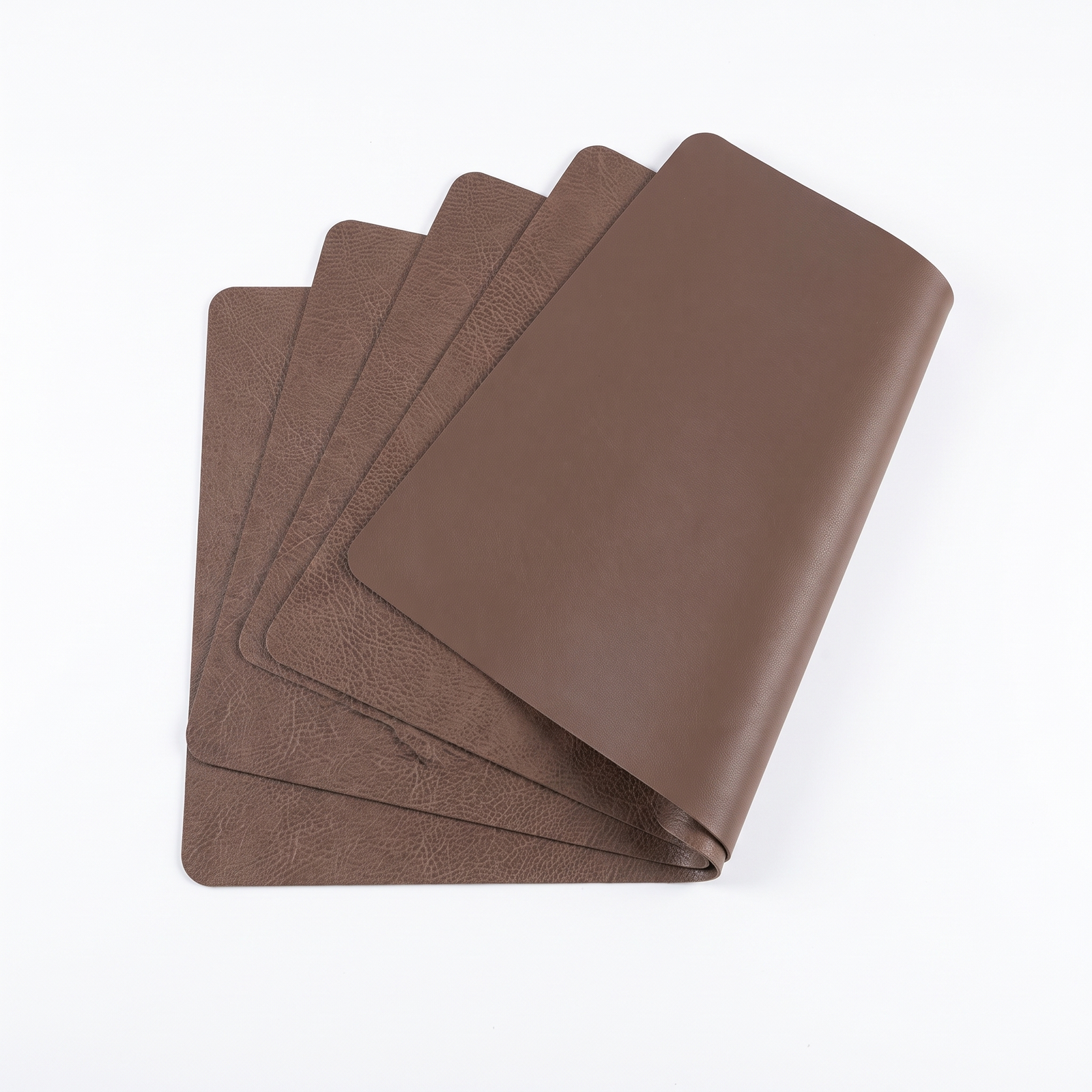 Double sided faux leather placemats on a white background