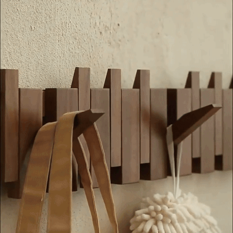 Piano style wooden flip hook rack mounted on a wall