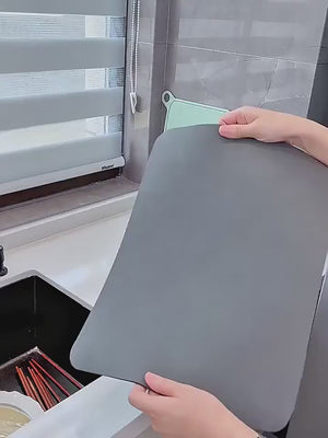 Quick dry dish mat being laid flat and smoothed onto a kitchen counter
